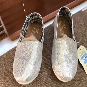 New girl Toms, never worn. Size 2, color silver glitter.